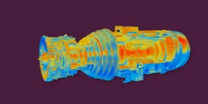 Thermal image of a large cylindrical mechanical component with rainbow heat-map colors against a dark purple background.